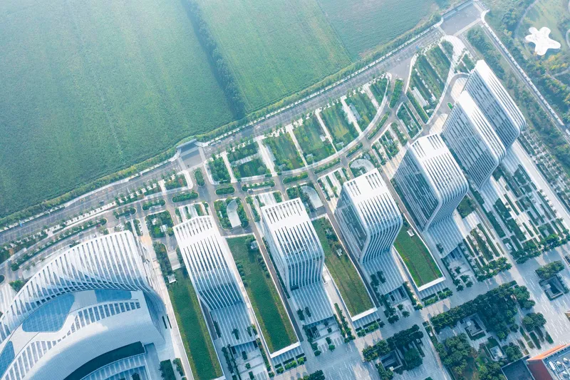 Oblique aerial of the undulating tower roofline and landscaped boulevards converging at a plaza