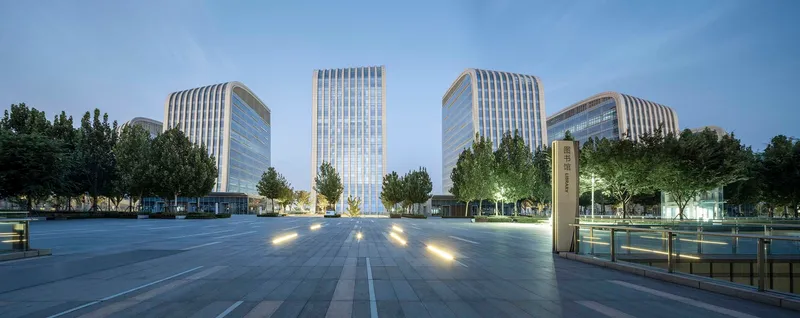 Wide plaza view with the tower cluster at dusk with ground lights illuminated