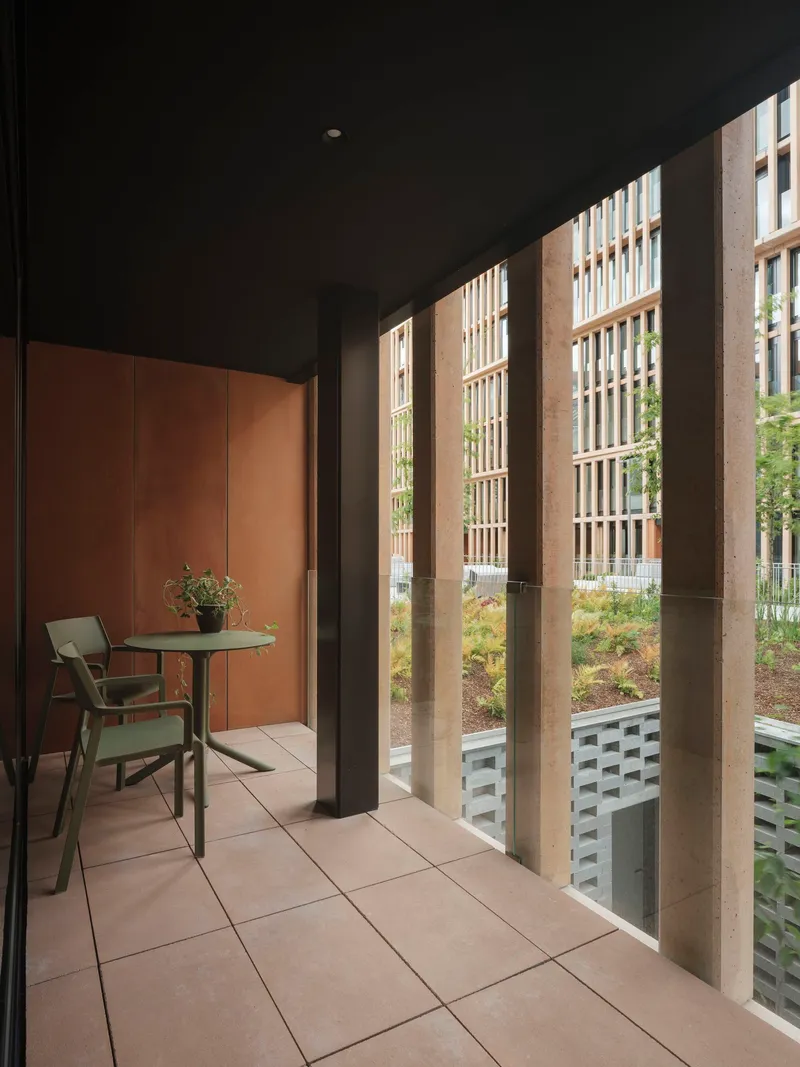 Interior hallway with vertical timber screening casting striped shadows onto tiled floor