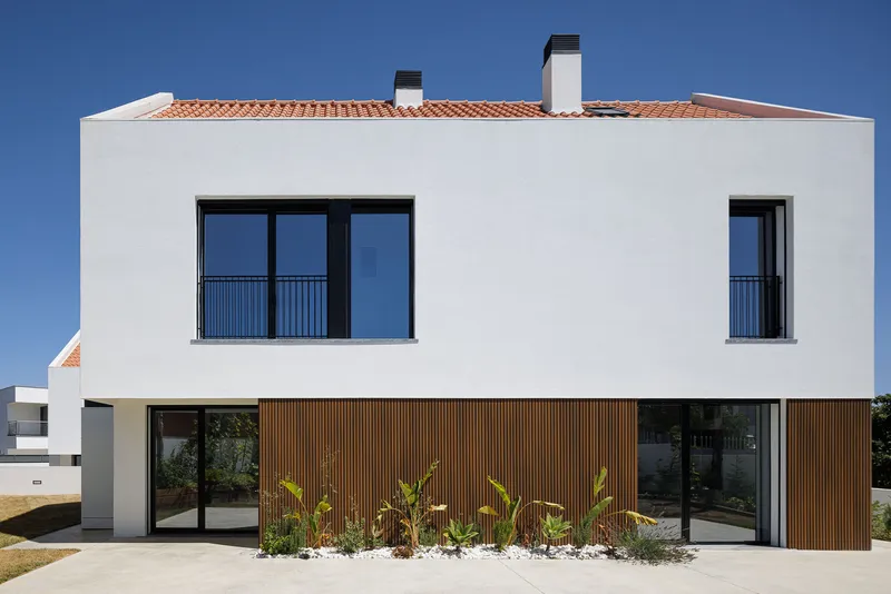 Garden elevation with timber slat cladding at ground level and planted bed with palms beneath clay tile roof