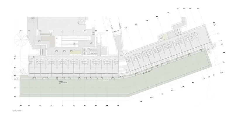 Site plan drawing showing an angled linear building with repetitive units fronting a large green space