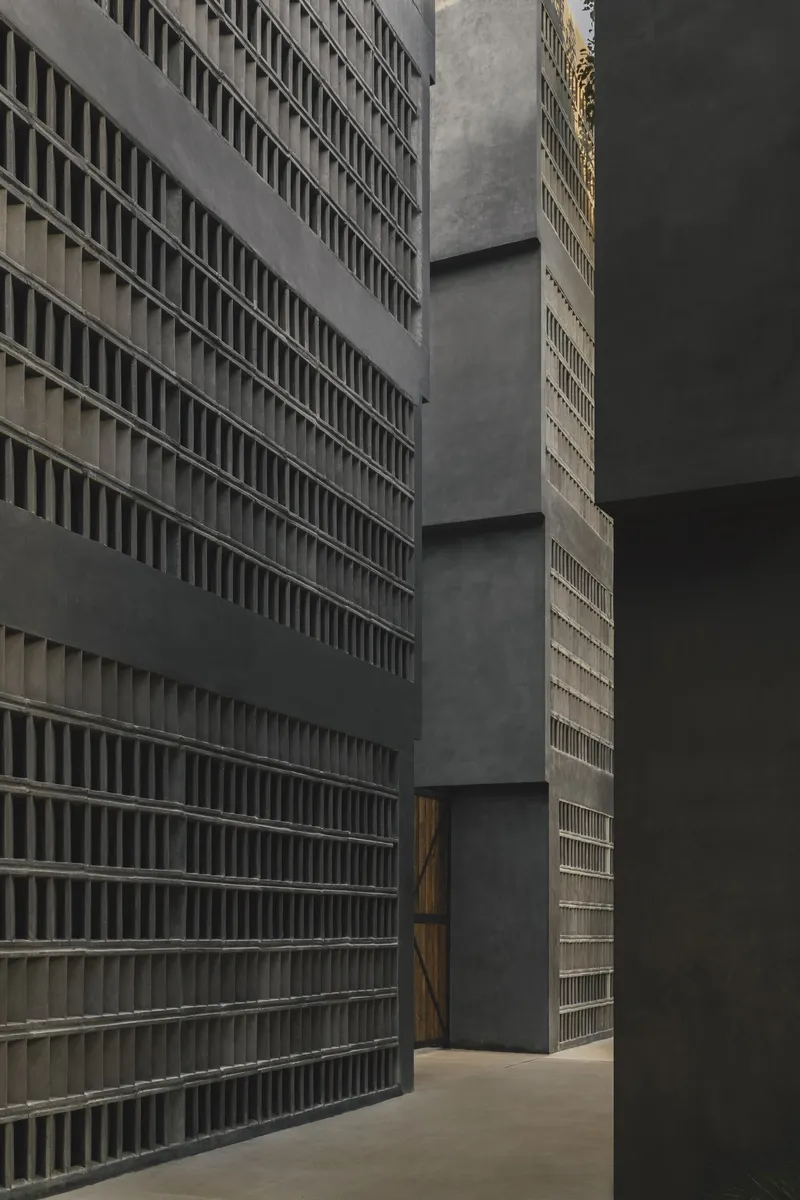Detail of concrete breeze block walls meeting smooth volumes at an interior corner