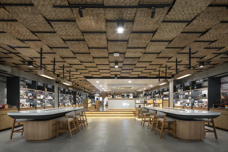 Tasting counter with wooden stools under a suspended woven bamboo ceiling panel system