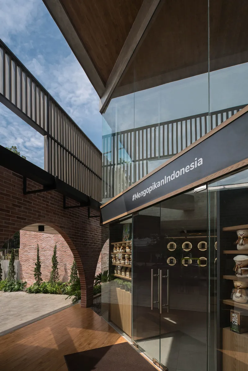 Glass entrance door beneath the angular canopy edge and timber slat screen in daylight