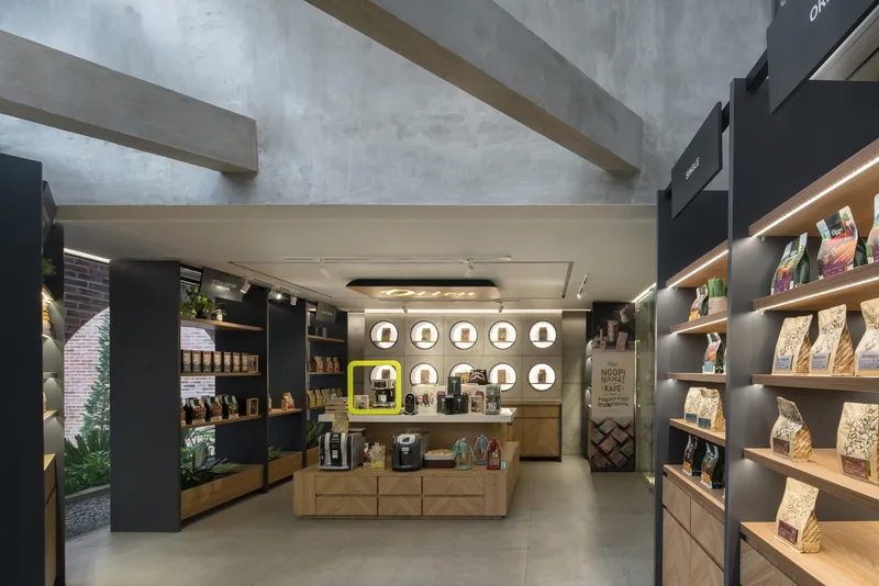 Retail interior with concrete beams overhead and circular display niches on the rear wall