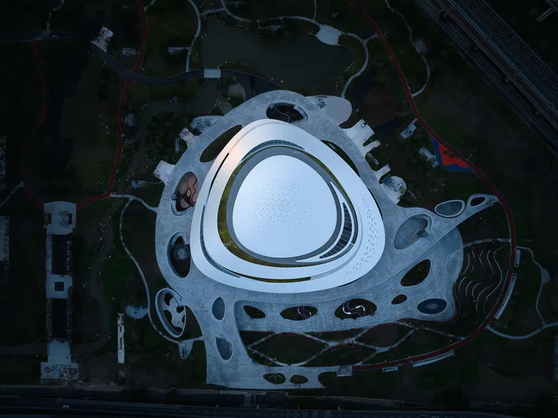 Top-down view of the triangular roof with perforated landscape deck and organic openings at twilight