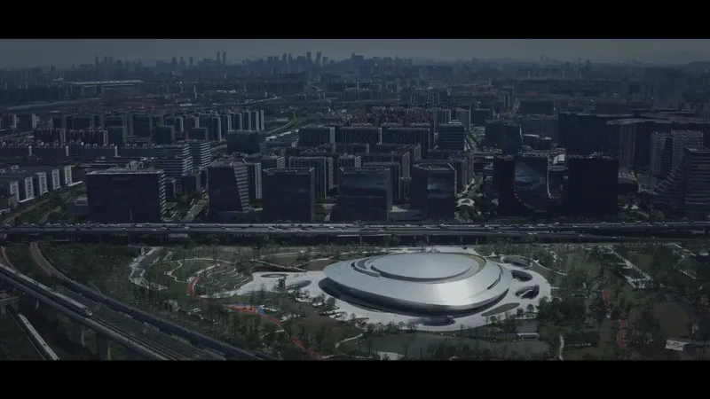 Aerial view of the circular roof amid parkland and urban blocks in afternoon light
