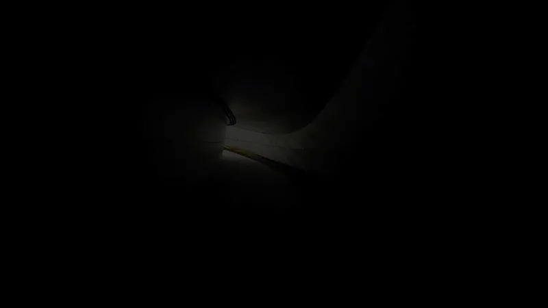 Narrow beam of light illuminating a person walking through a darkened corridor
