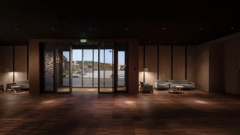 Wood-paneled foyer with glazed doors opening to an exterior courtyard in late afternoon light
