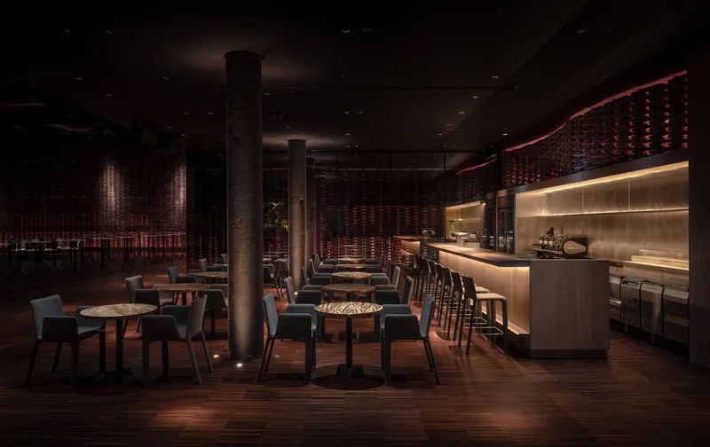 Bar area with curved woven ceiling feature and backlit shelving under low ambient lighting
