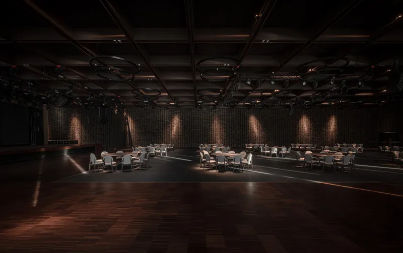 Banquet space with backlit brick wall segments and dining tables in low ambient light
