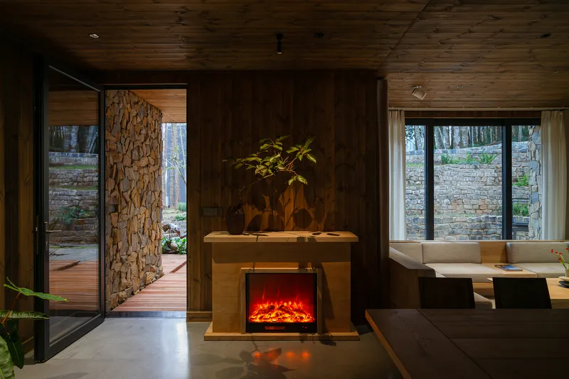 Living area with timber fireplace surround and glazed door opening to an exterior wood deck
