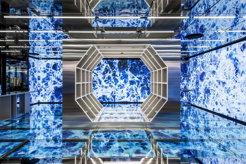Looking up through multi-story atrium with lit octagonal ceiling and blue tiled walls
