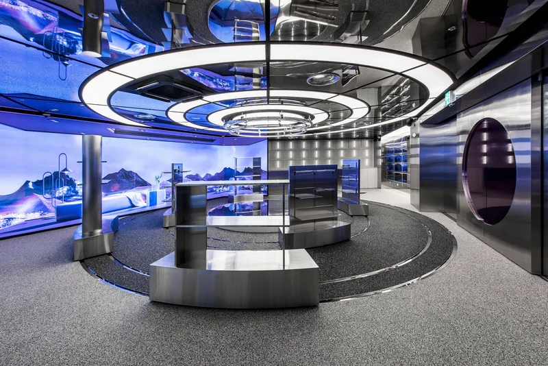 Interior showroom with circular counter below concentric ceiling rings and purple lighting