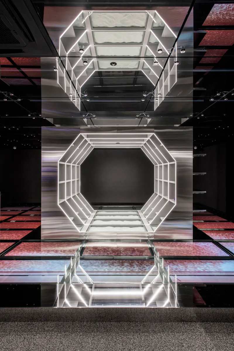 Vertical atrium view showing octagonal light frame reflected in polished floor below