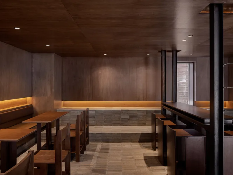 Timber seating nook with built-in benches and slatted base beneath continuous LED strip lighting in wood walls
