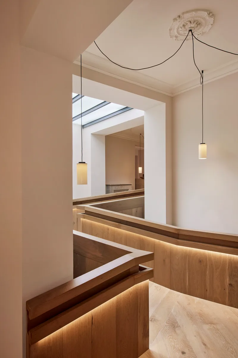View through doorway to timber pews with integrated strip lighting and pendant fixtures below ceiling rosette