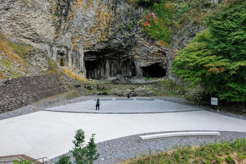 Elevated terrace with gravel borders and raised viewing platforms nestled against the columnar rock face