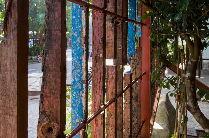 Vertical screen of salvaged painted timber slats framing view to street and planted courtyard