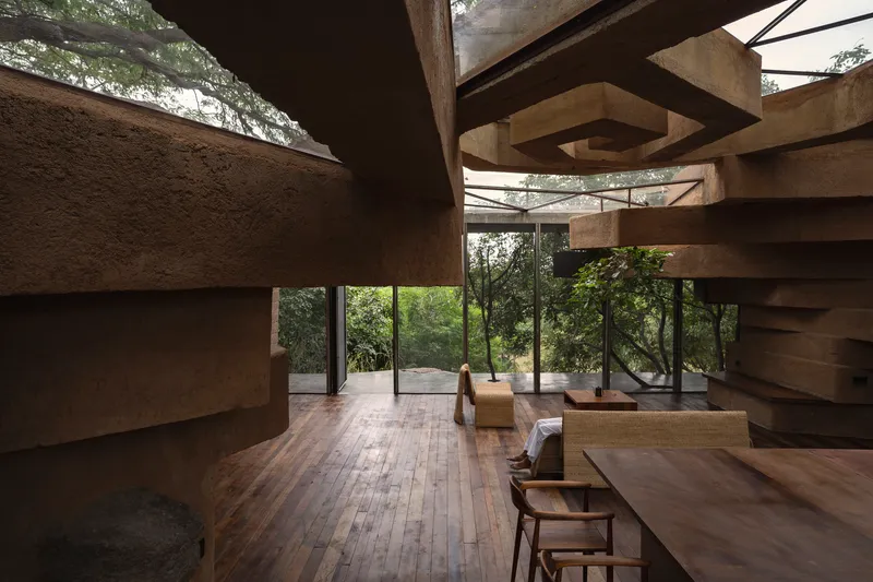 Double-height living area framed by horizontal concrete beams and full-height glazed walls