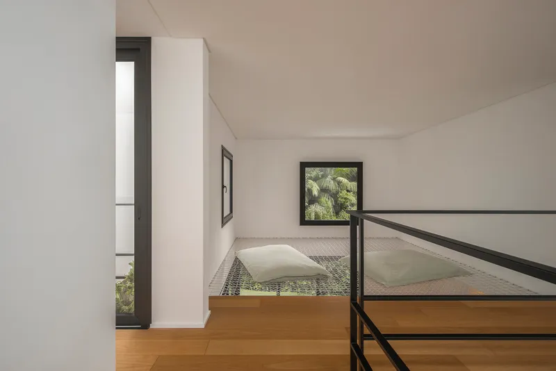 Upper level reading nook with mesh flooring and black metal railing overlooking the space below