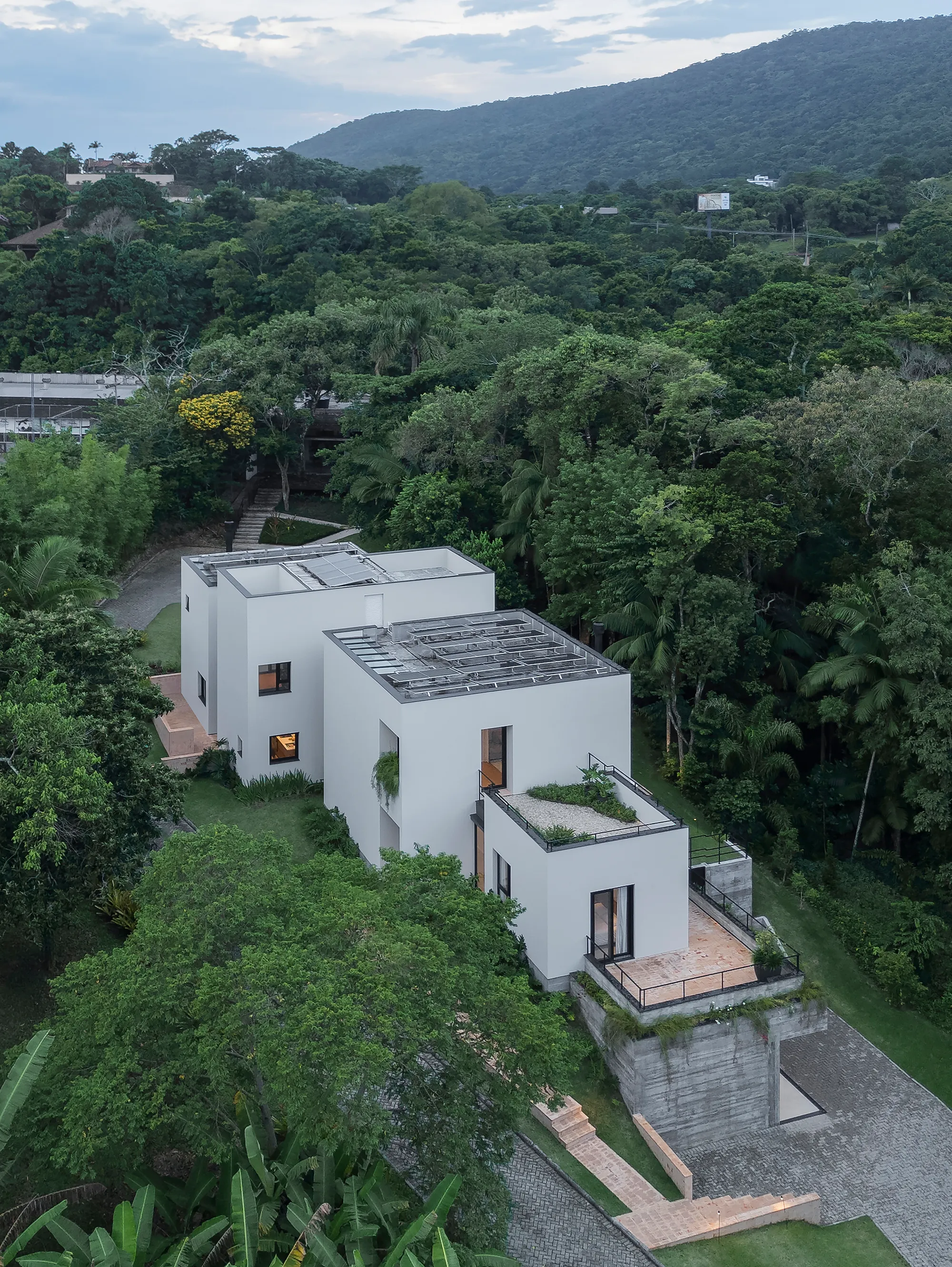 Nommo Arquitetos Fragments a House into Offset Volumes on a Forested Slope in Florianópolis