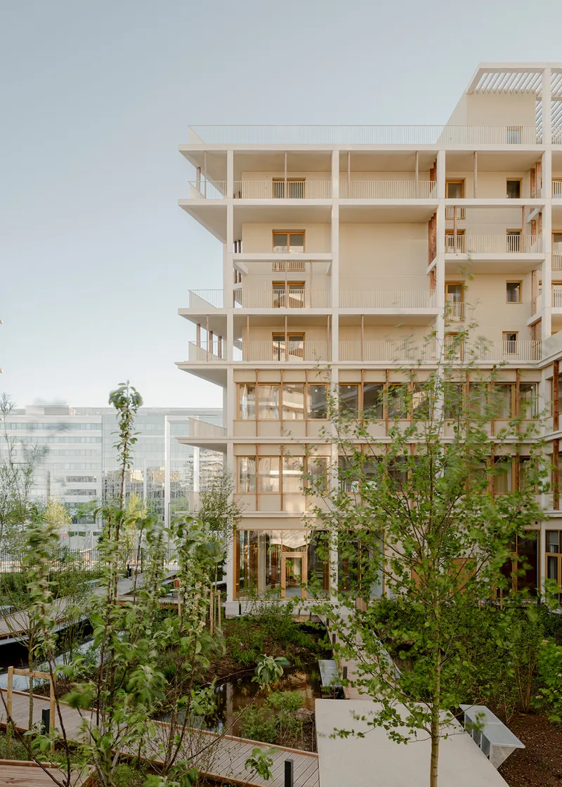 Exposed timber frame of the tower with balconies overlooking a planted garden courtyard