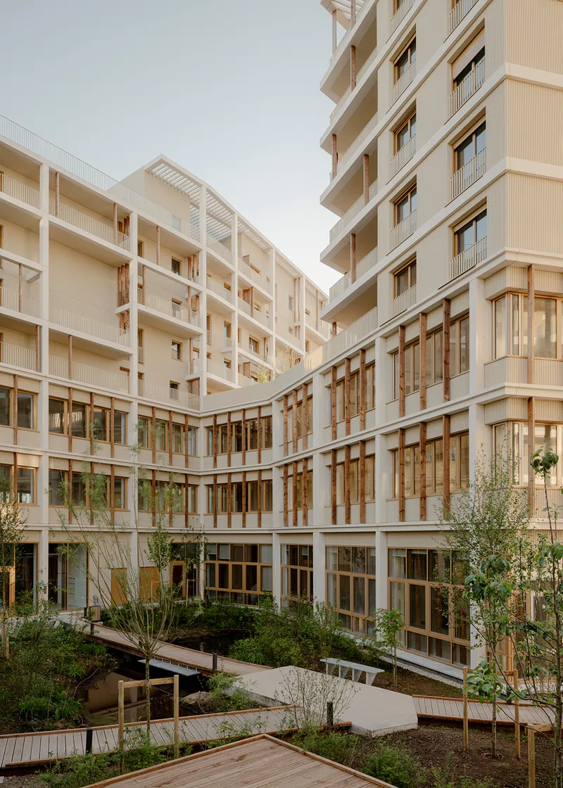 Interior courtyard framed by white timber facades with glazing and planted beds below