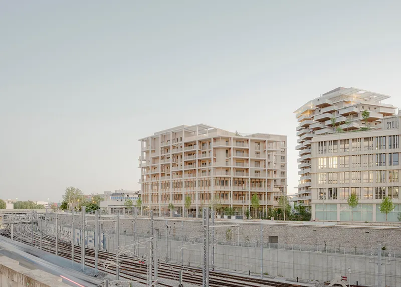 View of the timber-framed residential buildings from the railway tracks under an overcast sky