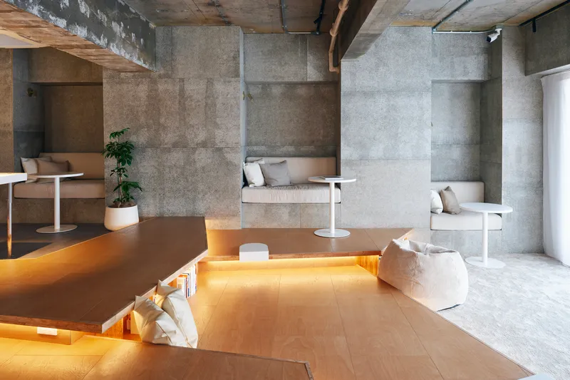 Stepped plywood platform with uplighting beneath the edges and concrete panel walls