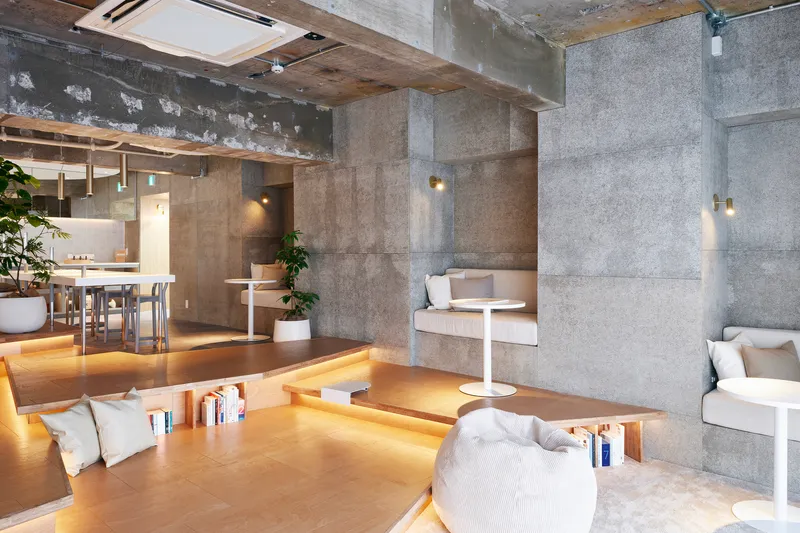 Communal seating area with concrete walls and timber ceiling under warm artificial light