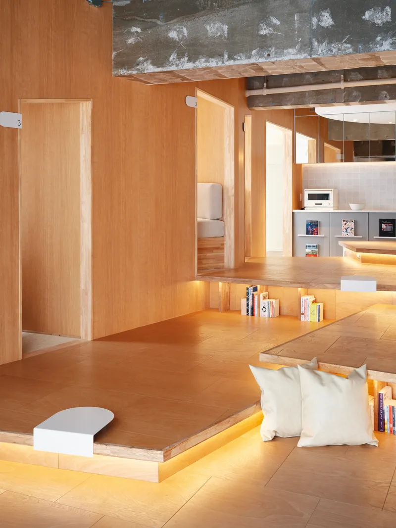 Sunken seating platform with integrated strip lighting and view through timber alcoves toward kitchen