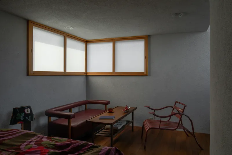 Bedroom with horizontal ribbon window framed in timber and diffused natural light