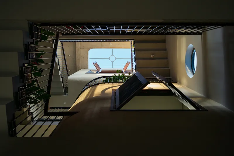 Looking up through the central atrium showing crossing bridges and circular skylights overhead