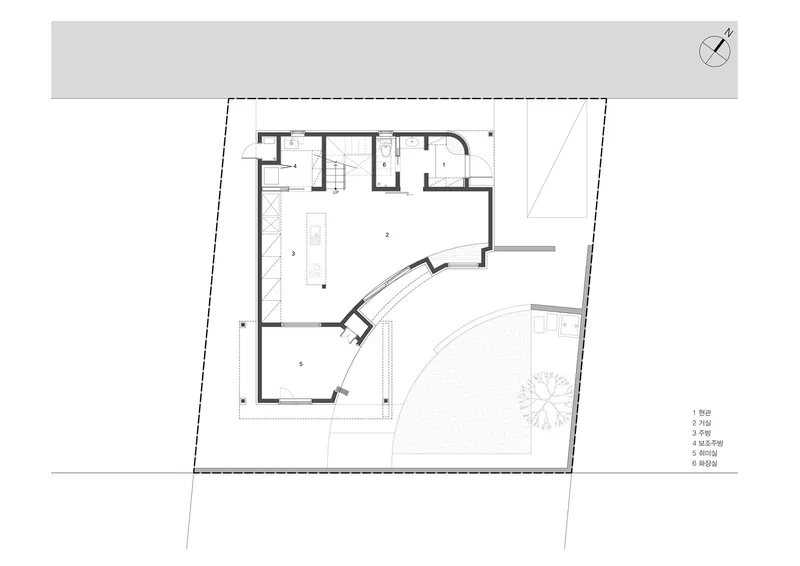 Ground floor plan drawing showing a curved corner volume with service rooms and an angled site boundary