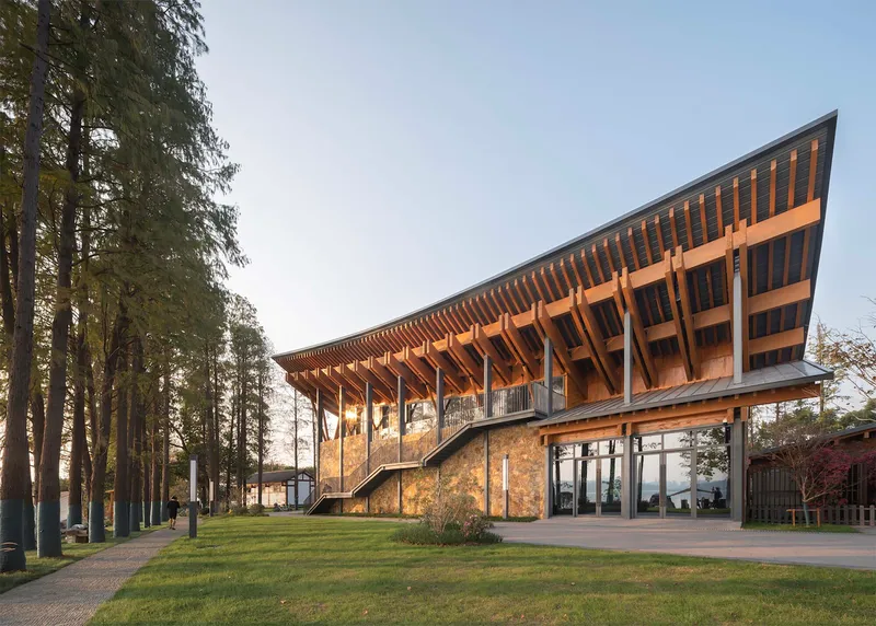 Side elevation showing angular timber roof rising above stone base with curved exterior staircase