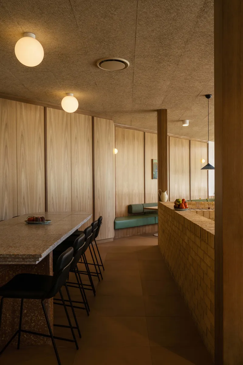 Dining area with cork ceiling panels, globe pendant lights, and vertical timber wall cladding