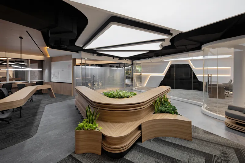Curved reception counter with integrated planter beds and glass-walled meeting rooms in the background