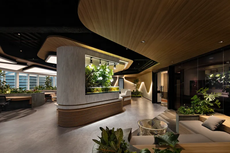 Reception desk with concrete and wood slat base beneath a curved timber ceiling with integrated planters