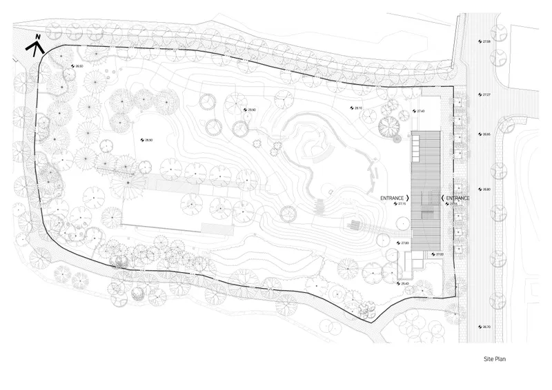 Site plan drawing showing the linear structure alongside curved pathways and landscaped topography