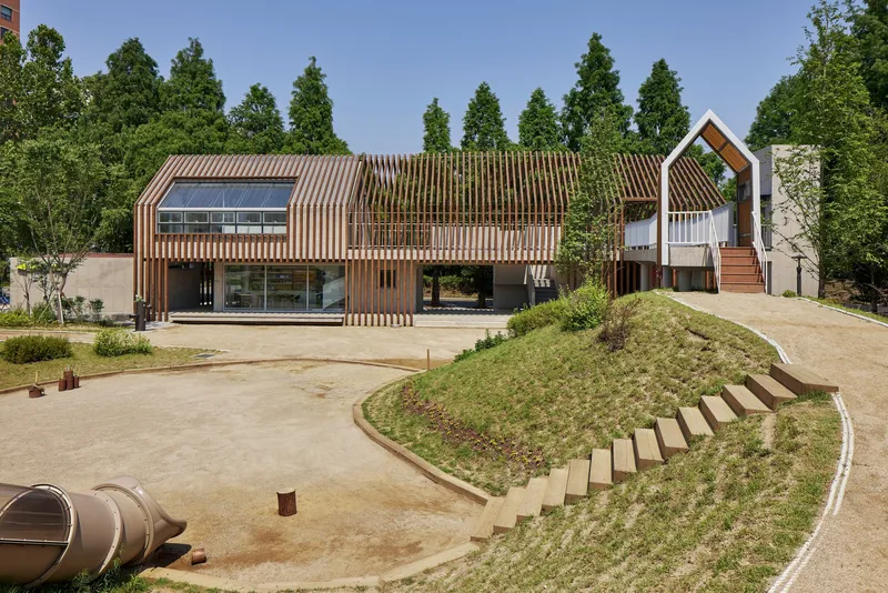 Front elevation with vertical timber slats screening the glazed facade and a house-shaped volume beyond