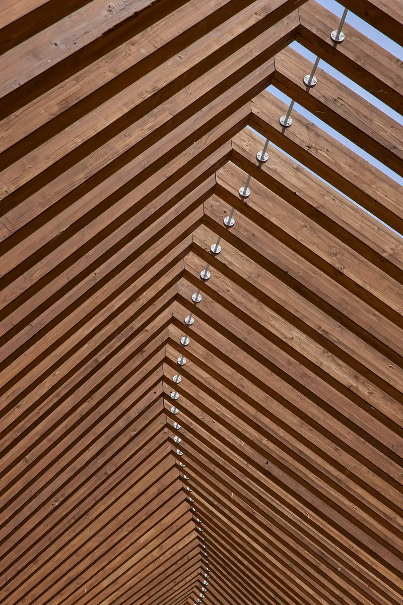 Close-up of the timber slat ceiling showing steel connectors along the ridge