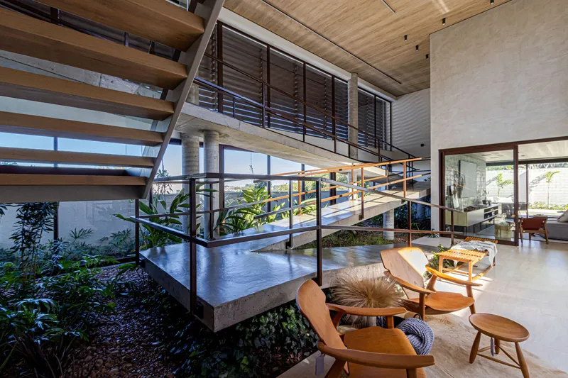 Multi-level interior void with open timber stair, concrete platforms and metal railings