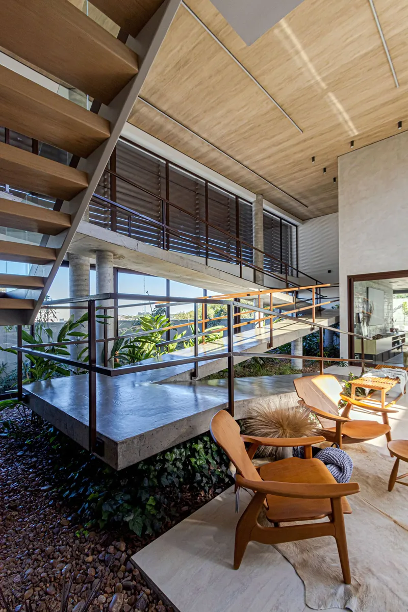 View across interior courtyard showing timber ceiling panels and horizontal louver screens above