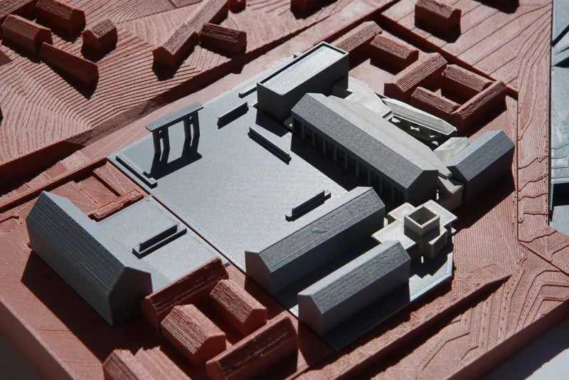 Aerial view of the physical model with grey roofs and a central courtyard surrounded by red buildings