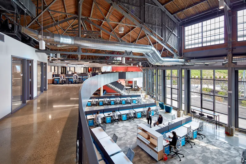 Upper floor balcony with polished concrete floors curving around the open office area below