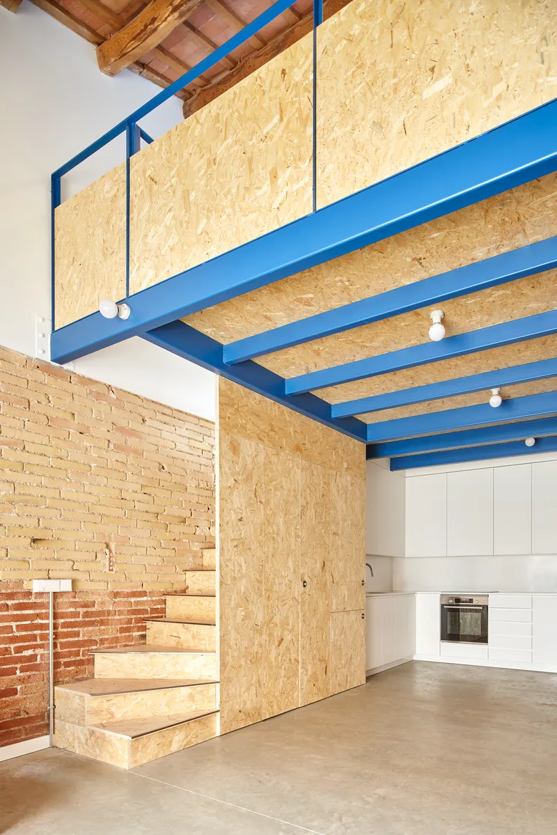Mezzanine level with oriented strand board cladding and blue steel frame above kitchen area