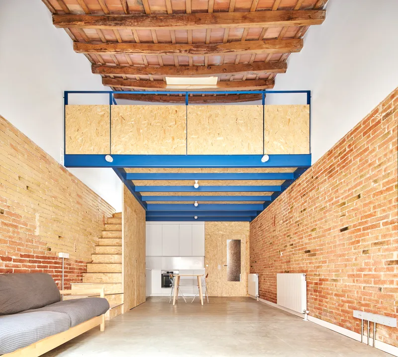 Interior view of blue steel mezzanine with oriented strand board panels beneath exposed timber beam ceiling