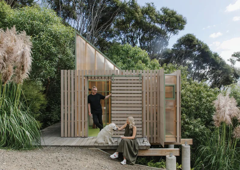 Timber slat facade with translucent polycarbonate panels and sliding doors, two people on the deck