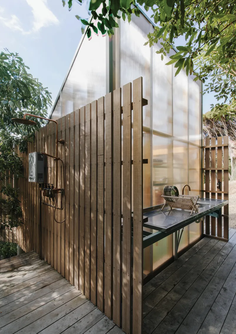 Timber deck with slatted screen wall and translucent polycarbonate wall illuminated by afternoon sun